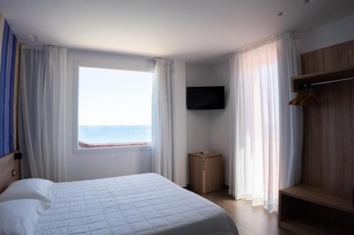a bedroom with a bed and a large window at Hotel La Martinica in Ficarazzi