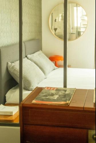 - une chambre avec un lit et une table avec un miroir dans l'établissement Loft parisien au coeur du marais, à Paris