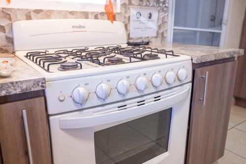 a white stove top oven in a kitchen at Arenales Guest House in Isabela