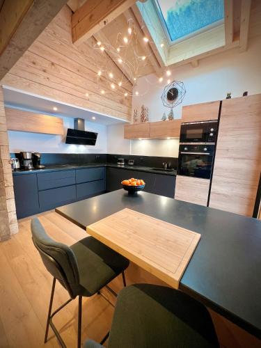 une cuisine avec une table et des chaises dans une cuisine dans l'établissement Chalet Valentine, à Les Deux Alpes