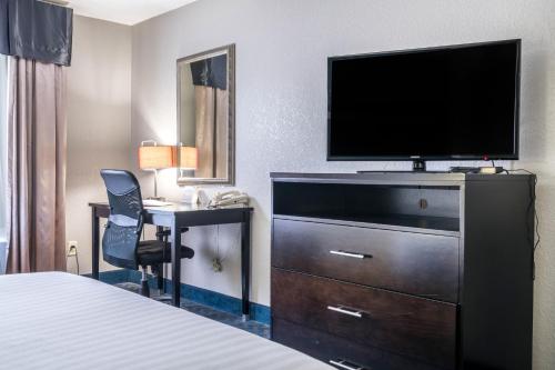 a hotel room with a bed and a television and a desk at Holiday Inn Express & Suites Roanoke Rapids by IHG in Roanoke Rapids