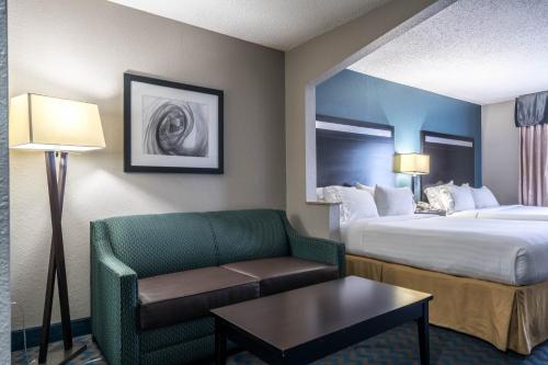 a hotel room with a bed and a couch at Holiday Inn Express & Suites Roanoke Rapids by IHG in Roanoke Rapids