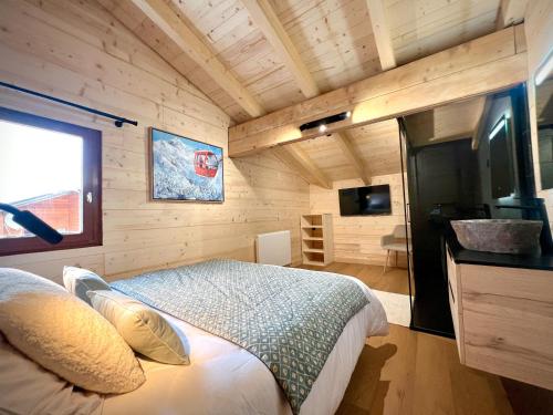 une chambre avec un lit dans une pièce aux murs en bois dans l'établissement Chalet Valentine, à Les Deux Alpes