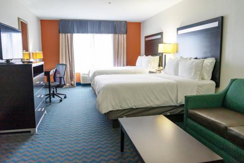 a hotel room with two beds and a couch at Holiday Inn Express & Suites Roanoke Rapids by IHG in Roanoke Rapids