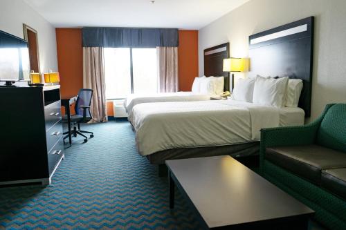 a hotel room with two beds and a couch at Holiday Inn Express & Suites Roanoke Rapids by IHG in Roanoke Rapids