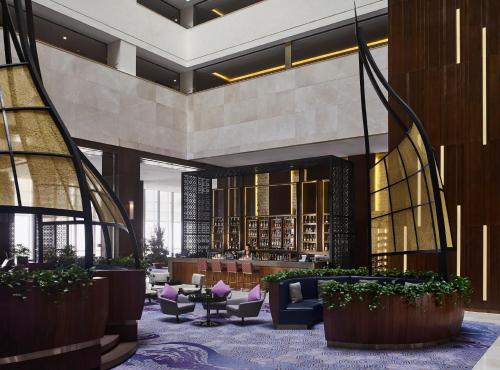 a lobby with a library with chairs and tables at InterContinental Hanoi Landmark72 by IHG in Hanoi
