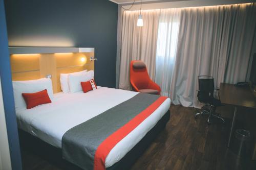 a hotel room with a large bed and a desk at Holiday Inn Express Milan-Malpensa Airport by IHG in Case Nuove