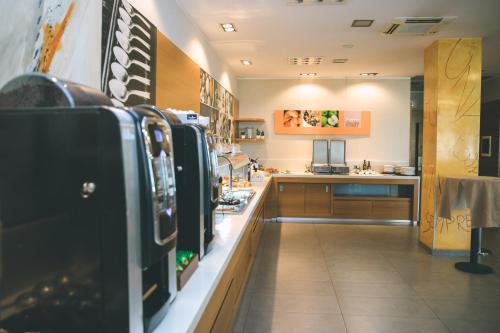 a large kitchen with a counter in a restaurant at Holiday Inn Express Milan-Malpensa Airport by IHG in Case Nuove