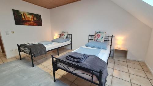a room with two beds and a table in it at Gästehaus Zimmer #4 Jülich in Jülich