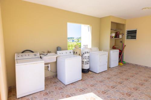 a laundry room with washing machines and a window at Arenales Guest House in Isabela