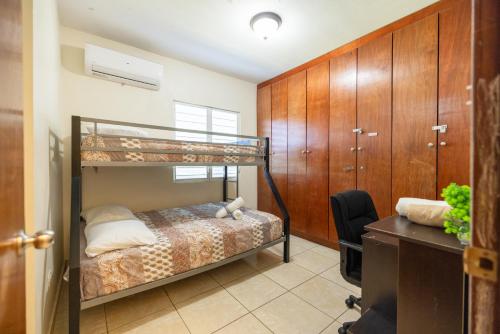 a bedroom with a bunk bed and a desk at Arenales Guest House in Isabela