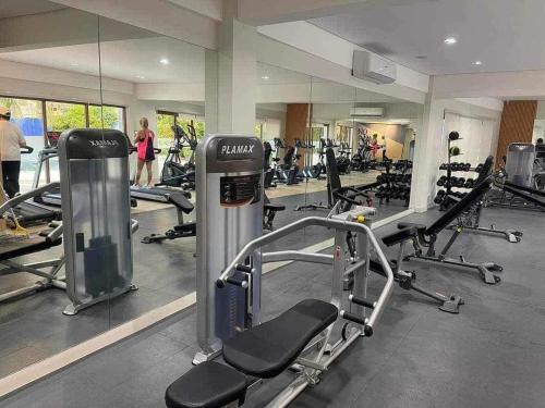 una palestra con macchinari per il cardio-fitness e persone sullo sfondo di Field Residences King Elite Near NAIA Arport a Manila