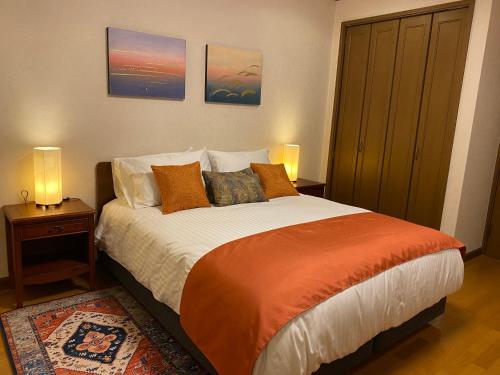 a bedroom with a bed with two night stands and two lamps at S & K Garden House in Tokyo
