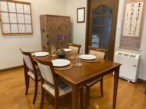 a dining room with a wooden table and chairs at S & K Garden House in Tokyo