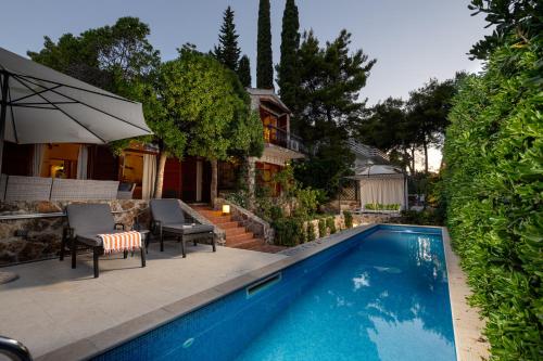 a swimming pool in front of a house at Villa Gallus - Jelsa, Hvar in Jelsa