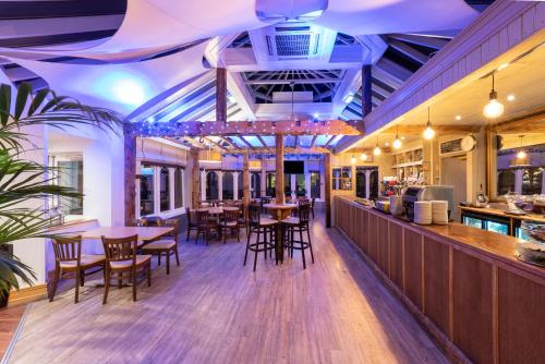 a restaurant with tables and chairs and a bar at Ardencote in Henley in Arden