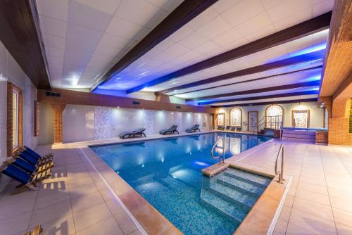 a large swimming pool in a building at Ardencote in Henley in Arden