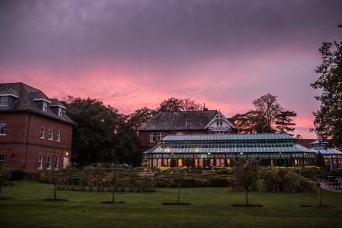 a building with a sunset in the background at Ardencote in Henley in Arden