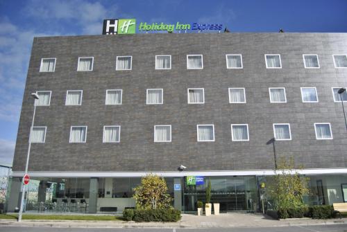 a large brick building with a sign on top of it at Holiday Inn Express Pamplona by IHG in Mutilva Baja