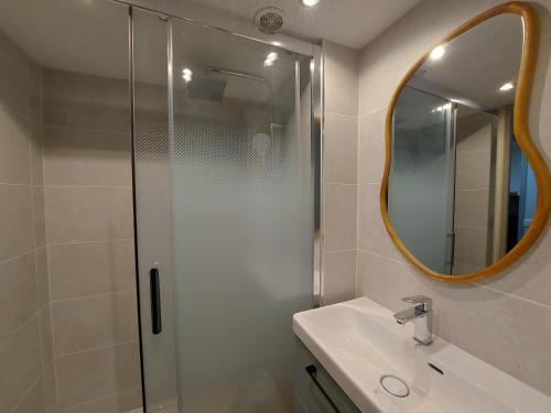 une salle de bain avec une douche, un lavabo et un miroir dans l'établissement Séjour à Arzon à deux pas du Port du Crouesty, à Arzon