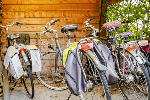 a couple of bikes parked next to a building at Light tiny house in green area with sauna option in Stoutenburg