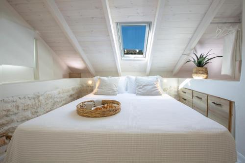 a bedroom with a bed with a basket on it at E Loft in Meganisi