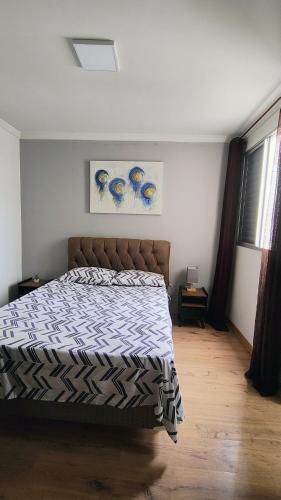a bedroom with a bed with a comforter on it at Apartamento Campo di Bourbon in São José dos Campos