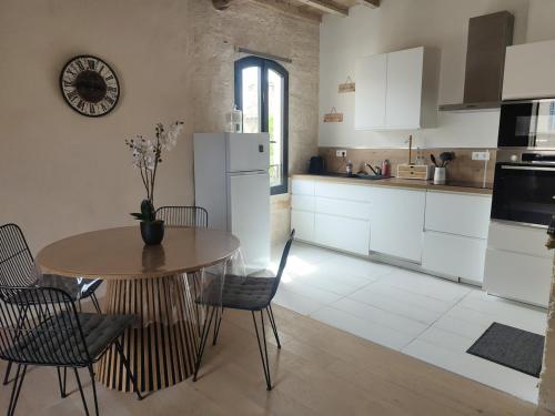- une cuisine avec une table, une table et des chaises dans l'établissement Le Nid de St-Marc, à Villeneuve-lès-Avignon