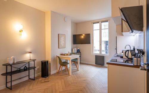 une cuisine avec une table et un comptoir dans l'établissement OIQIA • Palace Hôtel • N°1, à Tours