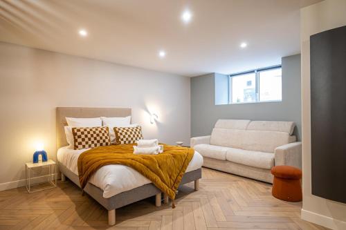 une chambre avec un lit et un canapé dans l'établissement OIQIA • Palace Hôtel • N°1, à Tours