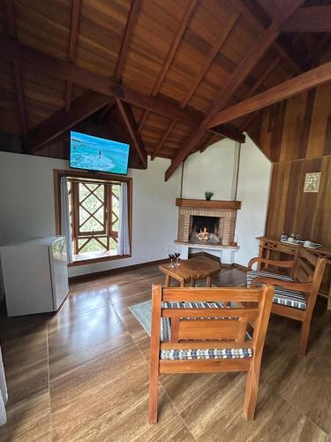 a living room with a bench and a fireplace at Recanto das Tirivas in Monte Verde