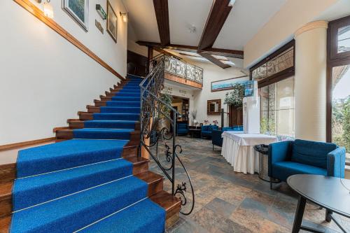 a set of stairs in a room with blue carpet at Hotel Amalia in Smokovce