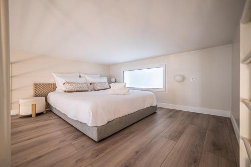 une chambre blanche avec un grand lit et une fenêtre dans l'établissement OIQIA • Palace Hôtel • N°2, à Tours