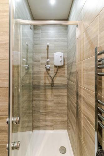 a shower with a glass door in a bathroom at Cozy Modern 1 Bed Flat Walsall Town Centre in Walsall