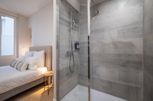 - une douche avec une porte en verre dans la chambre dans l'établissement OIQIA • Palace Hôtel • N°3, à Tours