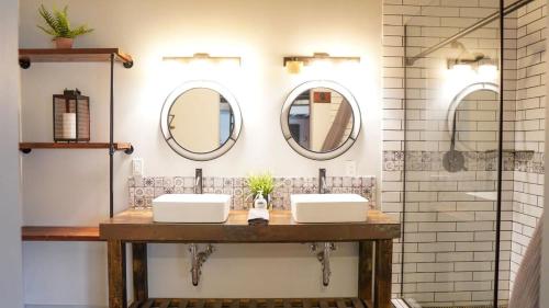 a bathroom with two sinks and two mirrors at Rivers Edge Lofts - Unit 5 in Niles