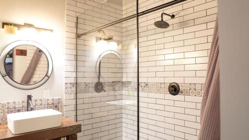 a bathroom with a shower with a sink and a mirror at Rivers Edge Lofts - Unit 5 in Niles