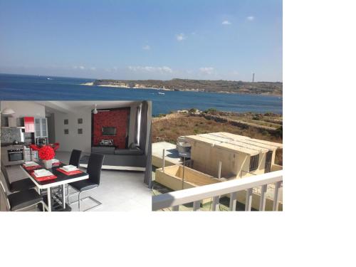 uma cozinha e uma sala de estar com vista para o oceano em Penthouse next to the beach em Marsaskala