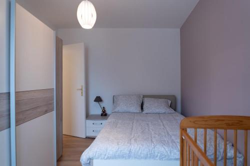 - une chambre blanche avec un lit et une lampe dans l'établissement D&D Home-Appartement Centre Historique Colmar-Parking gratuit, à Colmar