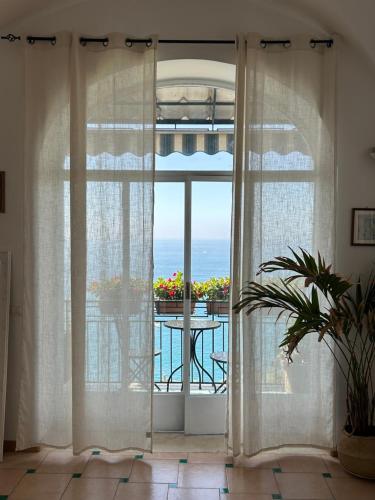 an open door to a balcony with a view of the ocean at Positano's Flats in Positano