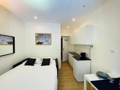 une chambre blanche avec un lit et une cuisine dans l'établissement Studio vieux port 1-1, à Marseille