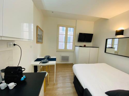 Cette chambre comprend un lit, un bureau et un lit. dans l'établissement Studio vieux port 1-1, à Marseille