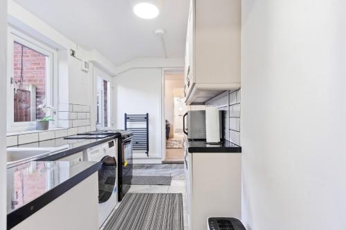 a kitchen with white counters and a sink at Wolverhampton Townhouse - 3BR - Business & Leisure guests in Wolverhampton