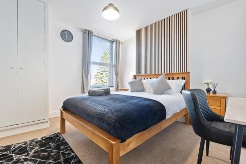 a bedroom with a bed and a desk and a chair at Wolverhampton Townhouse - 3BR - Business & Leisure guests in Wolverhampton