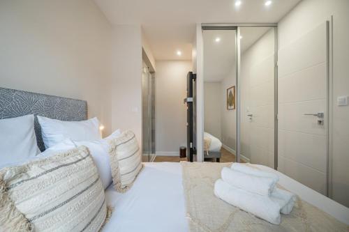 une chambre avec un lit avec des draps blancs et des oreillers dans l'établissement OIQIA • Palace Hôtel • N°6, à Tours