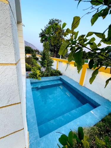 a blue swimming pool in the side of a building at Essence Of Sariska in Alwar