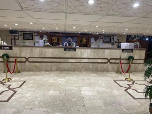 a lobby with a counter with red ropes in it at اجنحة روتانة الفرسان بالحمرا in Jeddah