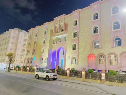 a car parked in front of a building with rainbow doors at اجنحة روتانة الفرسان بالحمرا in Jeddah