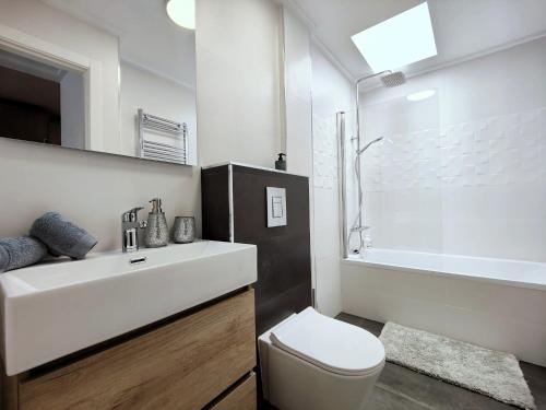 een badkamer met een wastafel, een toilet en een bad bij Salinas Luxury DaNuria in Torrevieja