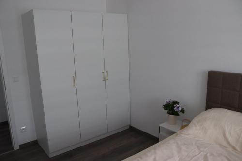 a bedroom with white cabinets and a bed at Apartmán Nerudova Zahrada in Polná